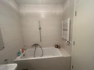 a white bathroom with a tub and a sink at Central Garden modern 1 bedroom condominium complex in Belgrade +8 photos