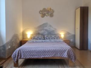 - une chambre avec un lit et deux lumières sur le mur dans l'établissement Noclegi na uboczu Dom Pstrąga, à Wetlina
