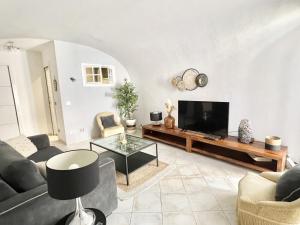 a living room with a couch and a tv at Les Logettes-plage-centre in Menton
