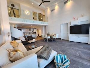 a living room with a couch and a flat screen tv at Exclusivos apartamentos con vista a la playa en Aquamarina, Cap Cana in Punta Cana