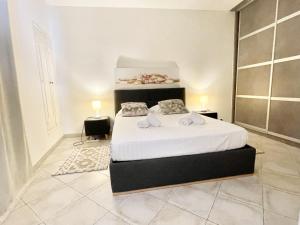 a bedroom with a bed with white sheets and pillows at Les Logettes-plage-centre in Menton