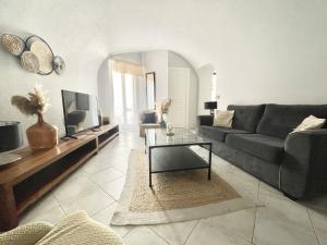 a living room with a couch and a table at Les Logettes-plage-centre in Menton +6 photos