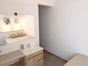Baño blanco con lavabo y espejo en Apartamentos Rincón de Vinatea, en Castellón de la Plana