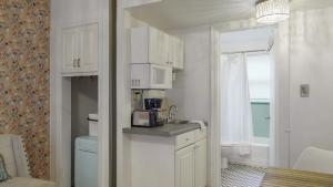 een kleine keuken met witte kasten en een wastafel bij Exclusive Access to a Gorgeous Private Beach 1BR in St Pete Beach