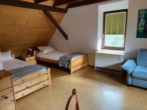 a room with two beds and a couch and a window at Landhotel Garni Knittelsheimer Mühle in Knittelsheim