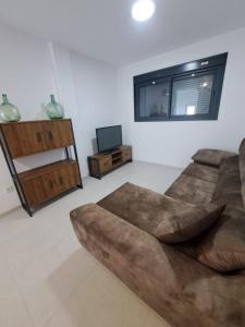 sala de estar con sofá y TV en APARTAMENTO TURISTICO EN LEBRIJA, en Lebrija