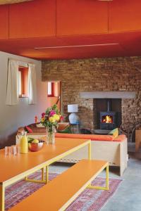 a living room with a table and a fireplace at A Digital Detox in the Cotswolds - Langley Barn in Winchcombe