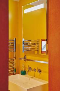 a yellow bathroom with a sink and a mirror at A Digital Detox in the Cotswolds - Langley Barn in Winchcombe