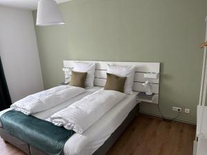 1 cama grande con sábanas y almohadas blancas en Hami Apartments Hannover, en Hannover