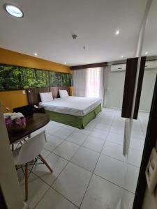 a hotel room with a bed and a desk and a bedroom at Lobie Nova Iguaçu in Nova Iguaçu