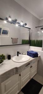 Un baño con un lavabo blanco y un espejo. en Luminous Studio in quiet area, en Tacoronte