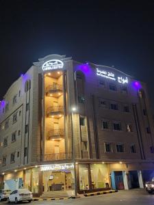 ein großes Gebäude mit einem Schild in der Nacht in der Unterkunft امواج للشقق المخدومة - Amwaj suites in Khobar