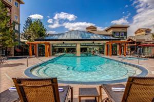 una gran piscina con 2 sillas y un edificio en Westgate Mountain Retreat en Park City