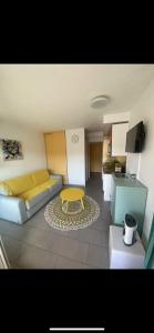 sala de estar con sofá y mesa. en Studio/f1bis à 50 m de la plage, en Argelès-sur-Mer