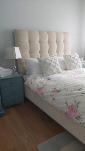 a bedroom with a bed and a lamp and a nightstand at Knockrobin Cottage in Wicklow