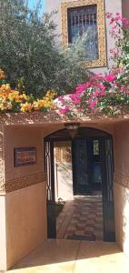 einen Eingang zu einem Gebäude mit Blumen und einer Tür in der Unterkunft Villa Korima in Marrakesch