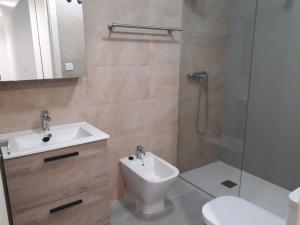 y baño con lavabo, aseo y ducha. en Apartamento Playa Blanca en Melilla