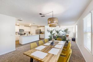 Arbor Retreat في جاكسونفيل: غرفة طعام ومطبخ مع طاولة خشبية وكراسي صفراء
