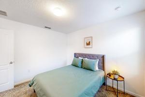 Schlafzimmer mit einem Bett mit blauer Bettwäsche und einem Tisch in der Unterkunft Arbor Retreat in Jacksonville
