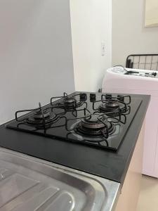 a black stove top in a kitchen with a sink at Apartamento à 380m do Mar in Itapema