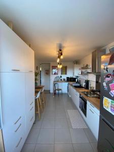 uma cozinha com um frigorífico branco e uma mesa em Chambre chez l'habitant proche centre em Brest