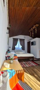 a bedroom with a large bed and a wooden ceiling at Cabana Bujor de Munte in Râşnov