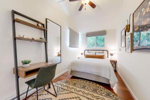 1 dormitorio con cama, escritorio y silla en Cozy Riverview Cabin, en Forestville