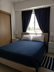Un dormitorio con una cama azul y una ventana en Boca Del Mar, Torre l, Apto. 412, en Boca Chica