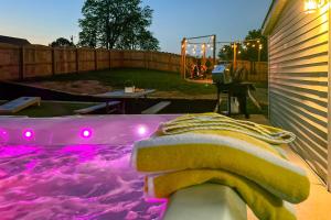 a hot tub with purple lights in a backyard at Shelbyville Farmhouse with Hot Tub, Fire Pit and Grill in Shelbyville