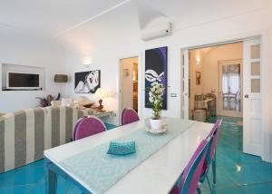 een woonkamer met een tafel en paarse stoelen bij fior di lino in Positano
