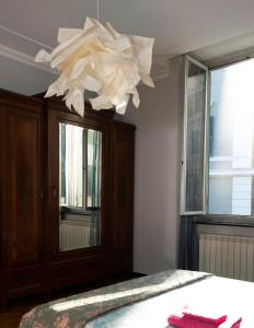 - une chambre avec un lit et un lustre blanc dans l'établissement ArtRoom in appartment, à Gênes