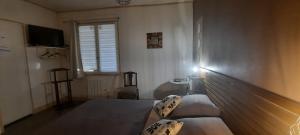 un soggiorno con un letto e una televisione di Chambres d'Hôtes L'Hermitage ad Anzex
