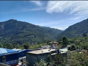 a view of a town with mountains in the background at 7coloursholidays in Kanthalloor