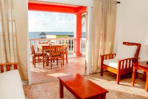 a living room with a table and chairs and the ocean at Mayan Princess Hotel in San Pedro