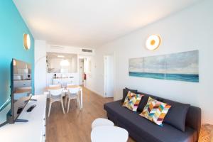 a living room with a couch and a table at Global Properties, Moderno apartamento con piscina en la playa de Canet in Canet de Berenguer