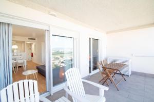 sala de estar con balcón con mesa y sillas en Global Properties, Moderno apartamento con piscina en la playa de Canet, en Canet de Berenguer
