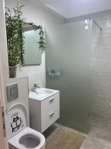 une salle de bains avec toilettes, lavabo et miroir dans l'établissement Black Sea Booking, à Mamaia