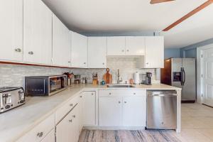a kitchen with white cabinets and a stainless steel refrigerator at Vermont Marble Haven - Unit 1 in Rutland
