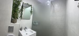 une salle de bains blanche avec un lavabo et un miroir dans l'établissement Black Sea Booking, à Mamaia 6 autres photos