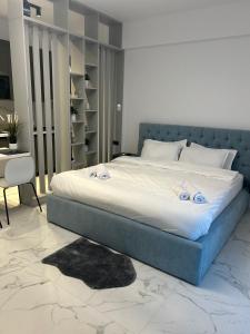 une chambre avec un grand lit avec une tête de lit bleue dans l'établissement Black Sea Booking, à Mamaia