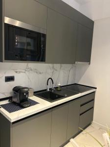 une cuisine avec un évier et un micro-ondes dans l'établissement Black Sea Booking, à Mamaia