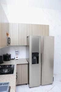 a kitchen with a refrigerator and a stove in it at Appartement Waves au Bord de mer in Cotonou