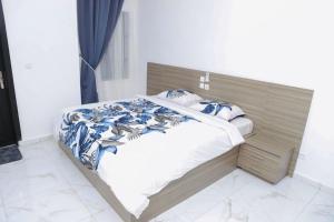 a bed with a wooden headboard in a bedroom at Appartement Waves au Bord de mer in Cotonou