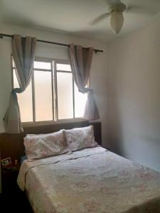 a bedroom with a large bed with a window at Apartamento para Temporada, sem vaga de garagem! in Belo Horizonte