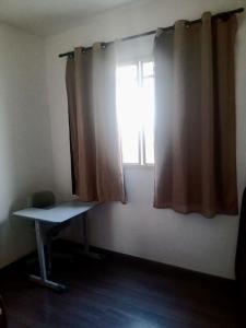 a room with a window with a desk and a window istg at Apartamento para Temporada, sem vaga de garagem! in Belo Horizonte