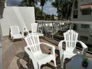 a group of white chairs sitting on a balcony at Boca del mar, apartamento 207/206 in Cuevas