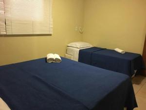 duas camas num quarto com lençóis azuis e toalhas em Dúplex 2 quartos no coração de Pipa em Pipa