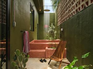 un patio con un sofá rosa y una silla en VERDE by DW en San Juan