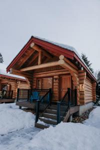 a log cabin with snow on the ground and stairs at Riverside Resort in Whistler