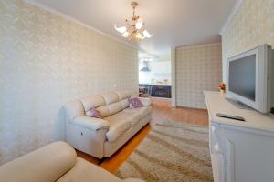 a living room with a couch and a tv at Five Stars Comfort in Chelyabinsk